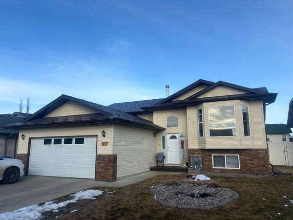 Tudor Brown Interlock Slate aluminum roof on a Tudor brown single-family home in a suburban neighbourhood, Red Deer, Alberta