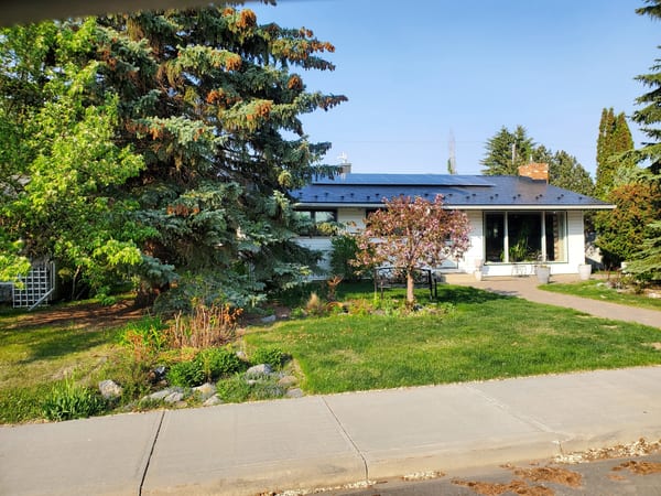 Black Interlock Slate aluminum roof on a white ranch home with a slate metal roof in a suburban, Edmonton, Alberta