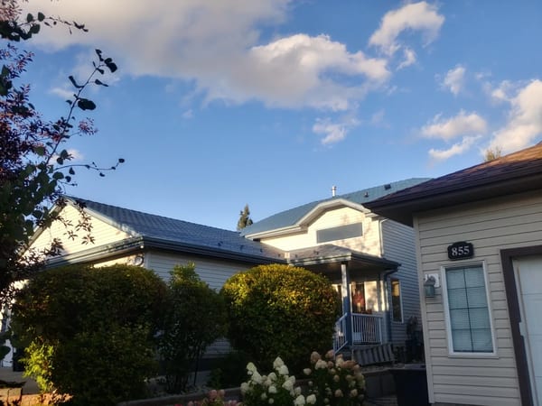 Royal Blue Interlock Slate aluminum roof on a beige bungalow with a metal roof in a rural, suburban, Devon, Alberta