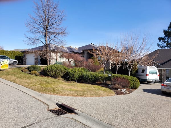 Tudor Brown Interlock Cedar Shingle aluminum roof on a Tudor brown single-family home in a suburban setting, West Kelowna, British Columbia