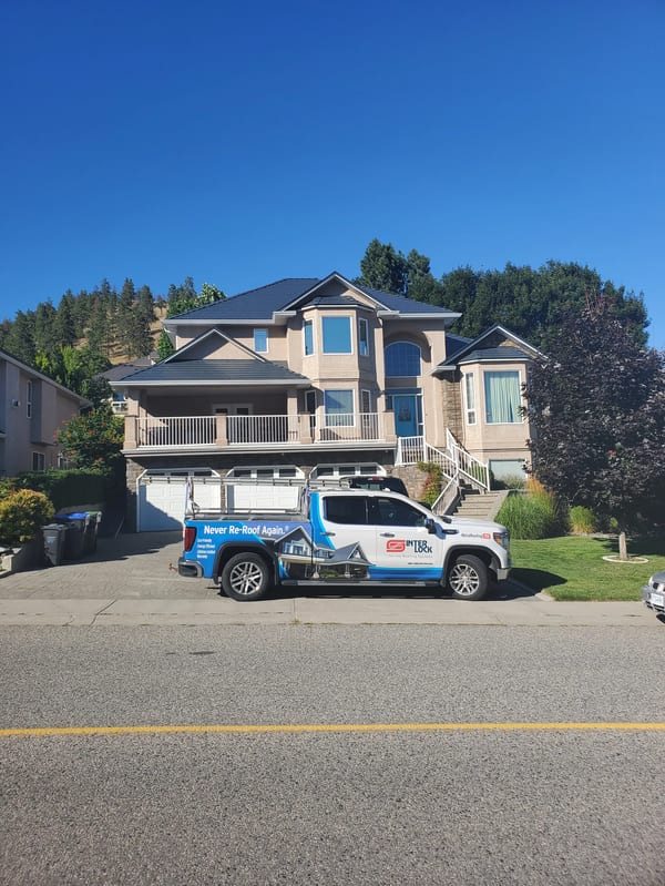 Deep Charcoal Interlock Slate aluminum roof on a modern single-family home with a metal roof in a forested, Kelowna, British Columbia