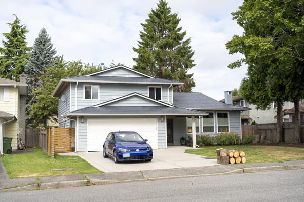 Deep Charcoal Interlock Slate aluminum roof on a two-storey home with a metal roof in a suburban forest, Richmond, British Columbia