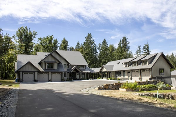 Large Craftsman-style home in Abbotsford BC with Interlock Musket Grey aluminum slate roofing across complex multi-gable rooflines and attached garage wing.