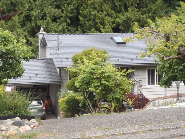 Deep Charcoal Interlock Cedar Shingle aluminum roof on a Deep Charcoal metal roof on a cottage in a forested rural, Ladysmith, British Columbia