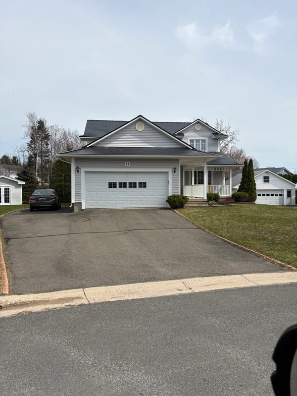 Black Interlock Slate aluminum roof on a white single-family home with a grey metal roof in a, Fredericton, New Brunswick