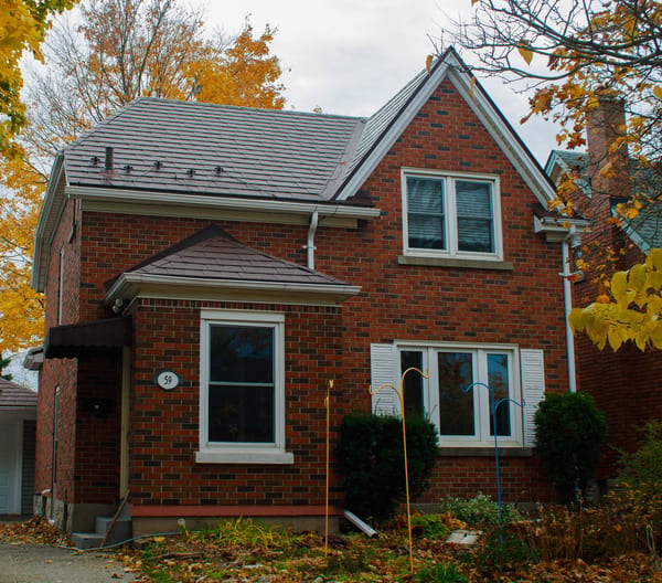 Two-storey brick Colonial home in Kitchener with Interlock Colonial Brown aluminum slate roof, hip and gable geometry, and snow guards visible along the lower slope.