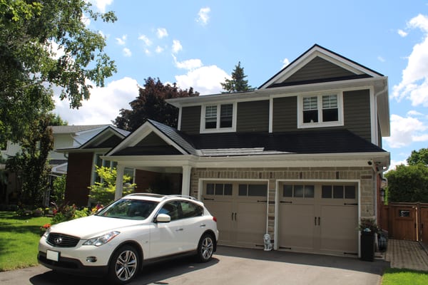 Two-storey Craftsman home in Markham ON featuring black Interlock aluminum slate metal roofing with complex multi-gable profile and stone facade.