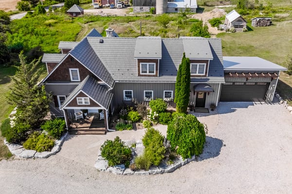 Aerial front view of a Craftsman home in Midland, ON with Interlock cedar shingle aluminum roofing in Weathered finish, featuring multiple dormers, valleys, and attached garage.