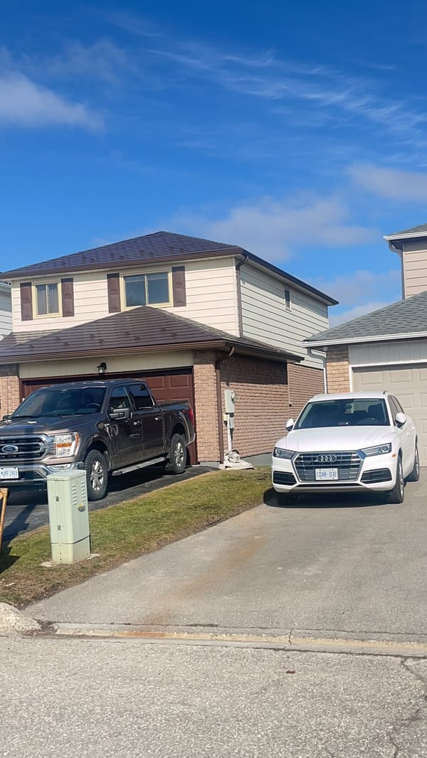 Two-storey Colonial home in Bradford, ON with Interlock aluminum slate roofing in Colonial Brown, hip roof profile, viewed from front elevation.
