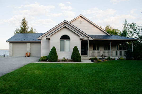 Single-storey ranch home in Owen Sound with Interlock deep charcoal aluminum slate metal roofing, covered front porch, and double garage.