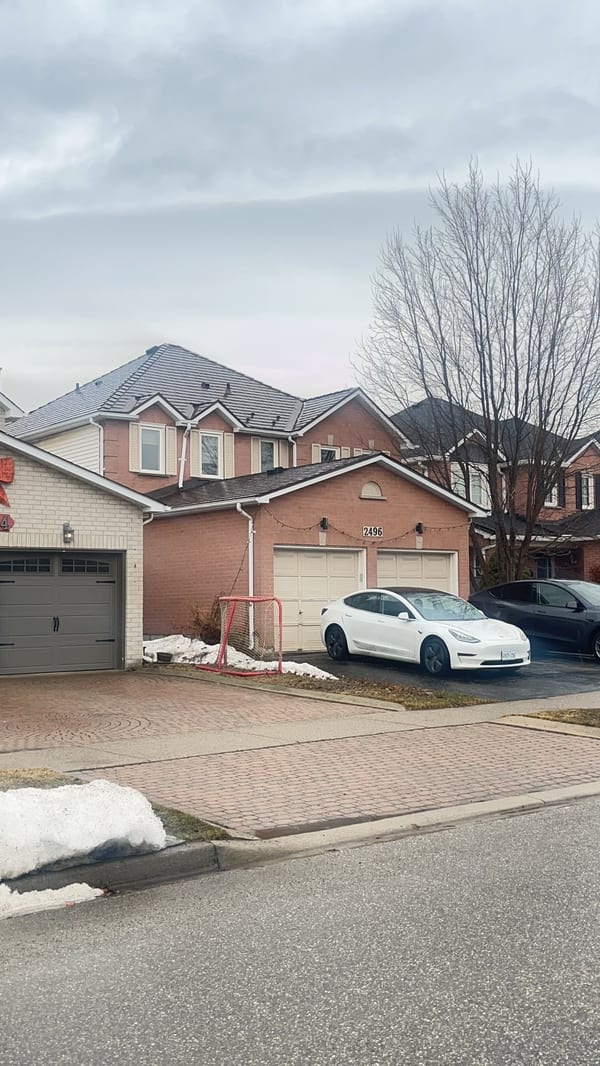 Two-storey suburban brick home in Burlington ON with Interlock Colonial Brown cedar shingle metal roof featuring multi-hip complex roofline and dormers.