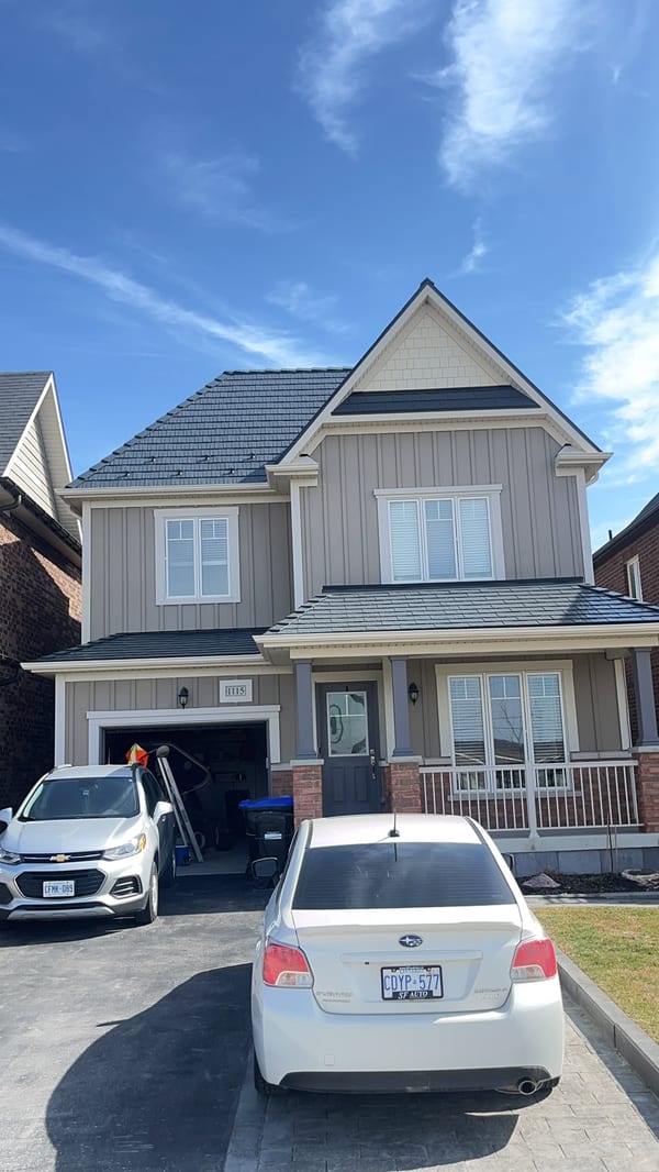 Two-storey Craftsman home in Innisfil ON with deep charcoal Interlock aluminum cedar shingle metal roofing on a steep multi-plane roof.