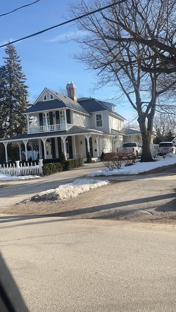 Victorian home in Collingwood ON with deep charcoal Interlock aluminum slate roof, wrap-around porch, dormers, and brick chimney in winter.