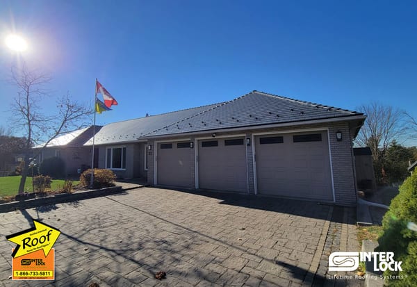 Single-storey ranch home in Nepean, ON with Interlock deep charcoal aluminum slate metal roofing on a hip roof, three-car garage, and brick exterior.