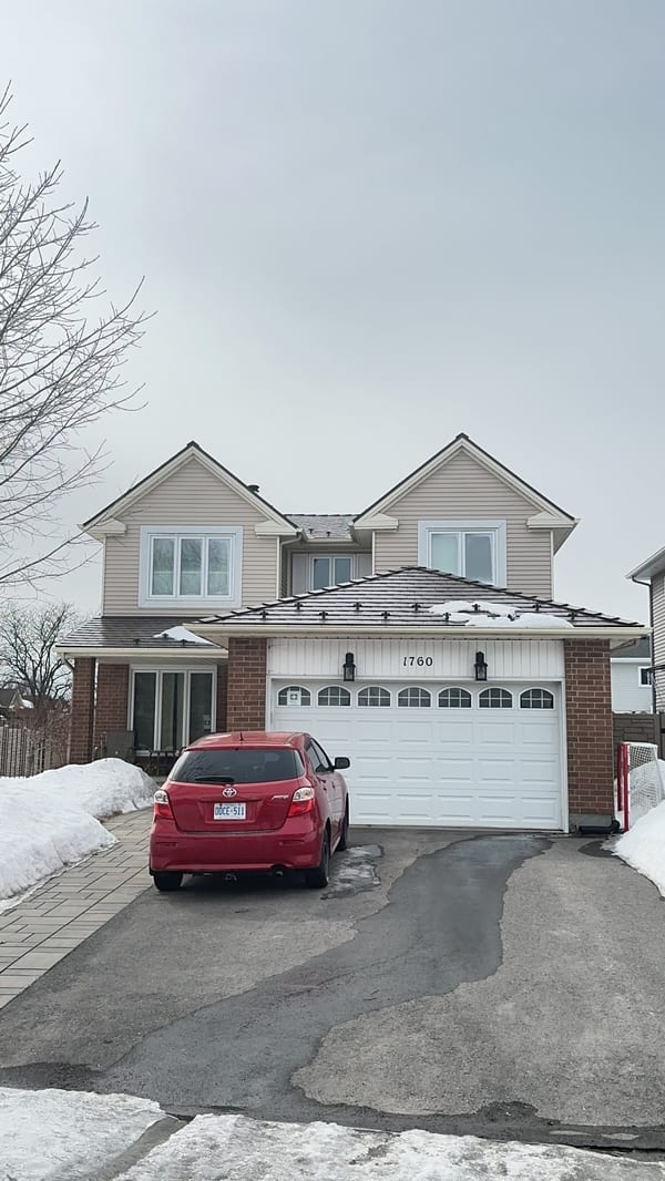 Two-storey colonial-style home in Ottawa with Interlock Colonial Brown aluminum slate metal roofing, twin dormers, and brick facade, photographed in winter.