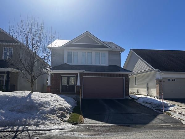 Two-storey Craftsman home in Orleans ON with Interlock deep charcoal aluminum slate metal roofing, brick lower facade, and attached garage.