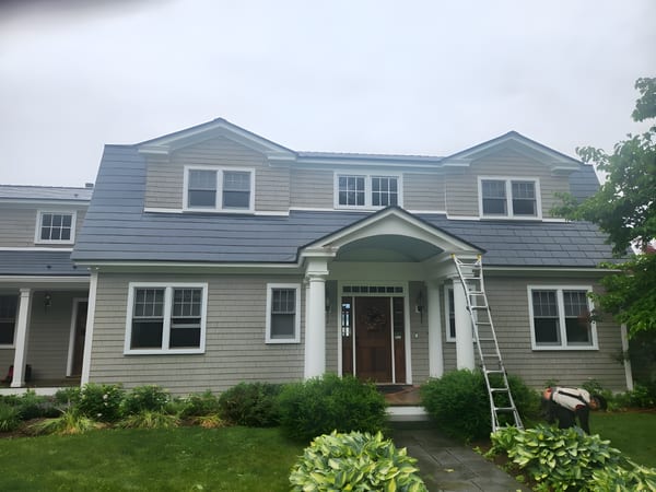 Two-story Colonial home in Panton, VT with Interlock deep charcoal aluminum slate roof featuring three front dormers and a mansard profile.