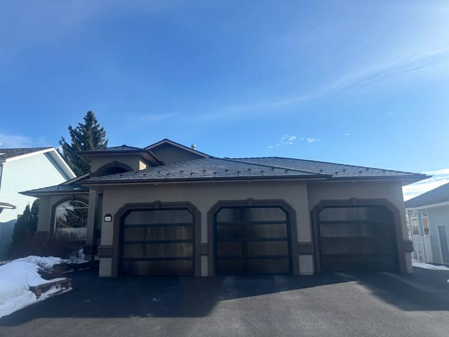 Black Interlock Slate aluminum roof on a beige ranch style home with snow on the ground, Red Deer, Alberta