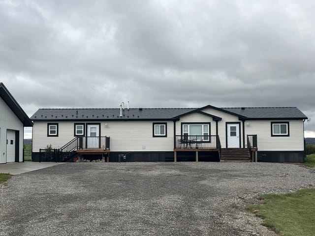 Black Interlock Cedar Shingle aluminum roof on a white ranch home with a black metal roof in a rural, Foothills County, Alberta