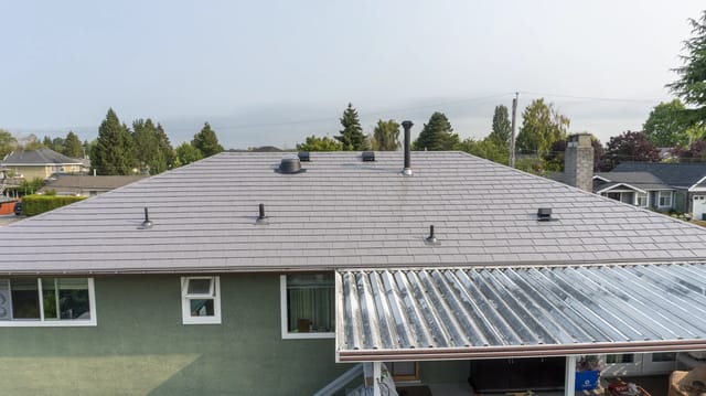Taupe Interlock Slate aluminum roof on a taupe metal roof on a green ranch-style home in a, Delta, British Columbia