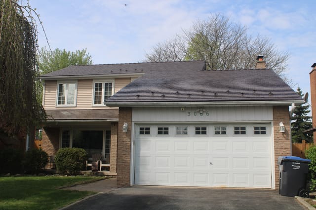 Two-storey Colonial-style home in Mississauga with Interlock aluminum cedar-shingle metal roofing in Colonial Brown, featuring snow guards and a brick chimney.