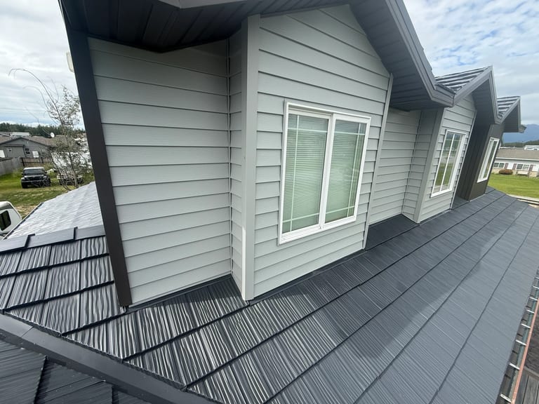 A modern metal roof with a grey finish on a single-family home in a suburban area.