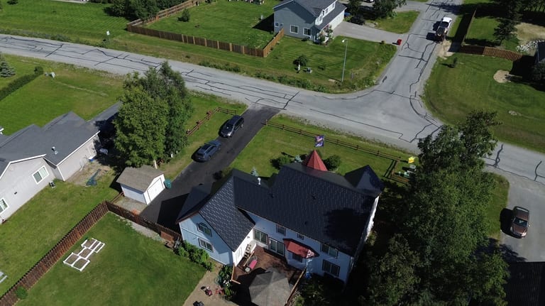 A white colonial home with a black metal roof