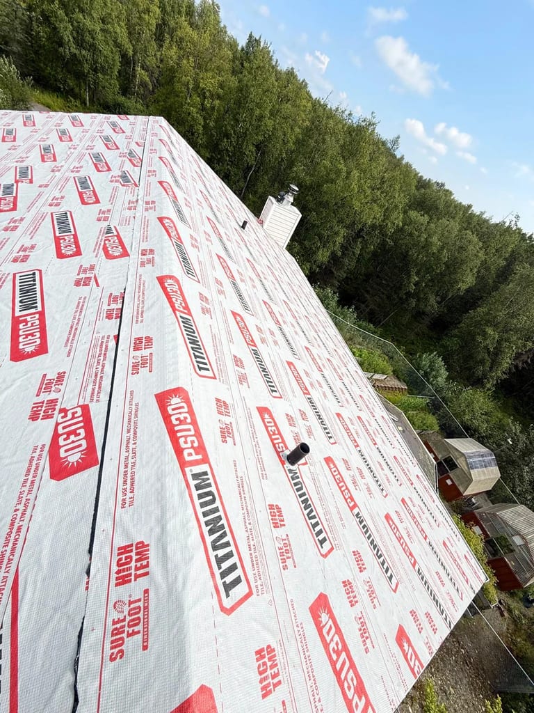 A modern metal roof installed on a single-family home in an urban area on a sunny day.