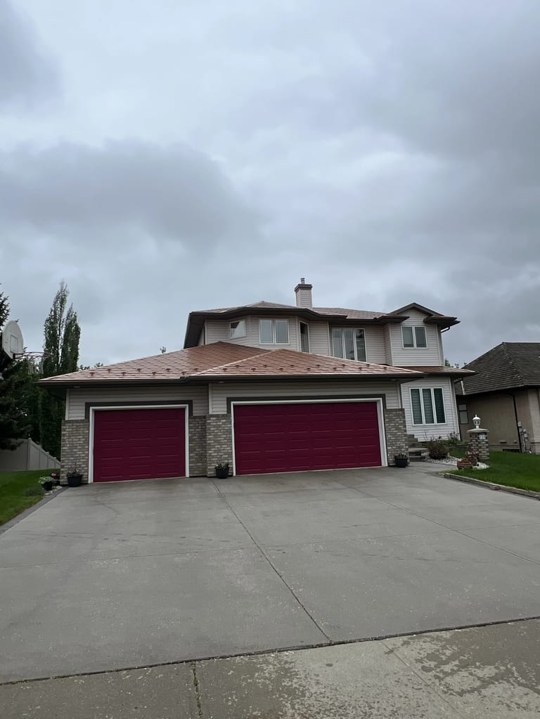 Aged Copper Interlock Slate aluminum roof on a beige two-storey home with dormers in a suburban, Sherwood Park, Alberta