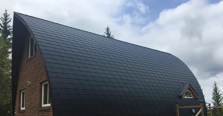 Black Interlock Slate aluminum roof on a brown single-family home with a metal roof among tall, Whitecourt, Alberta