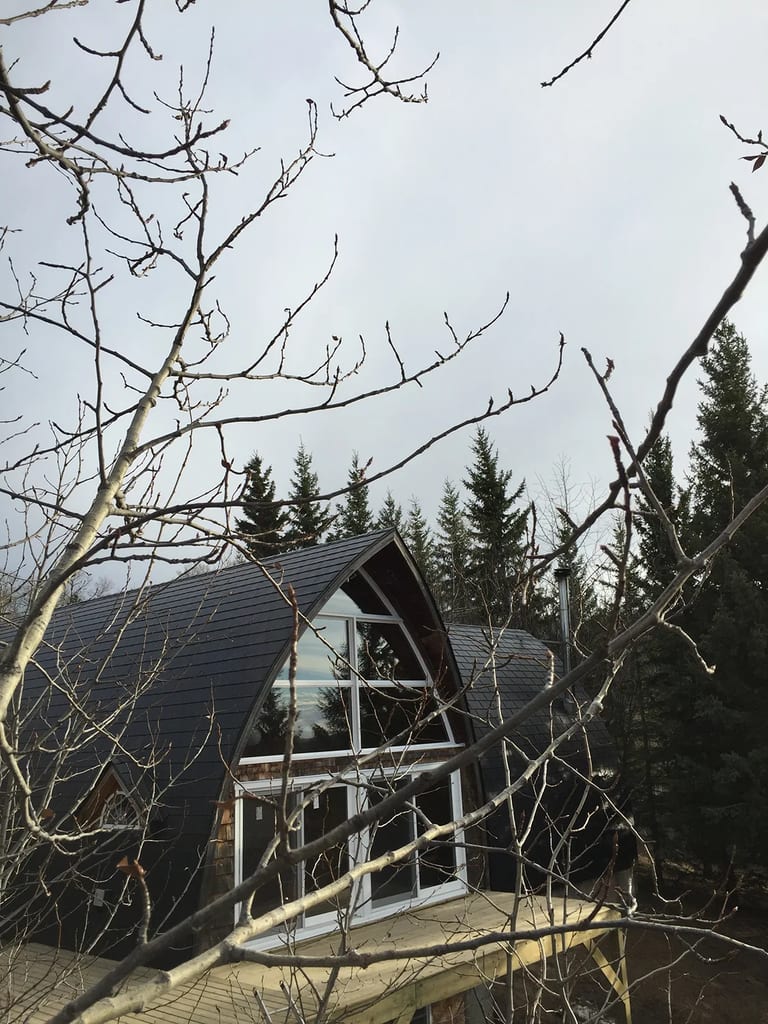 Black Interlock Slate aluminum roof on a black metal roof on a chalet style house in the forest, Whitecourt, Alberta