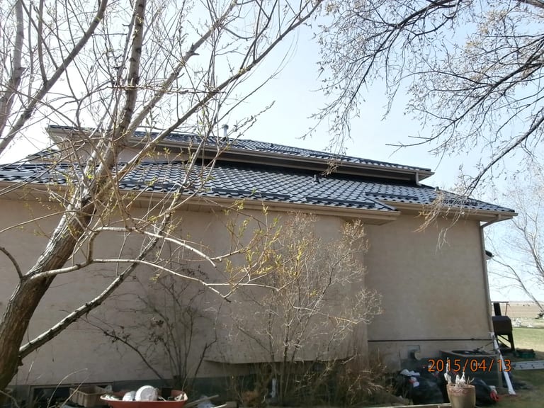 Black Interlock Tile aluminum roof on a two-storey home with dormers in a rural setting, Redcliff, Alberta