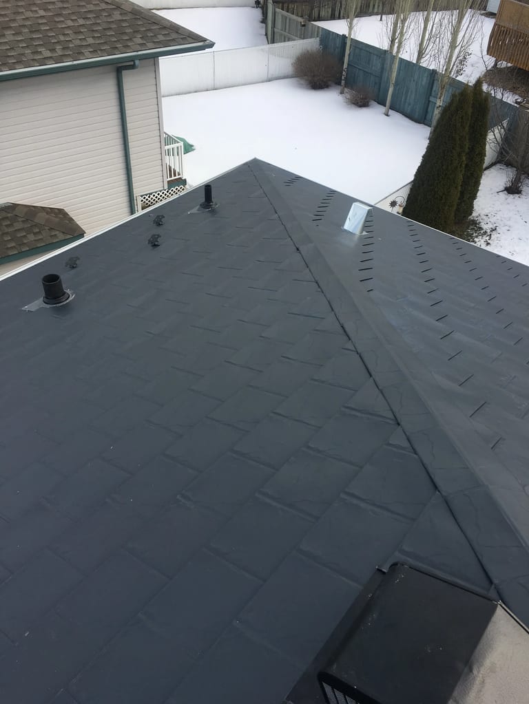 Deep Charcoal Interlock Slate aluminum roof on a single-storey home with a metal roof in a snowy rural, Fort Saskatchewan, Alberta