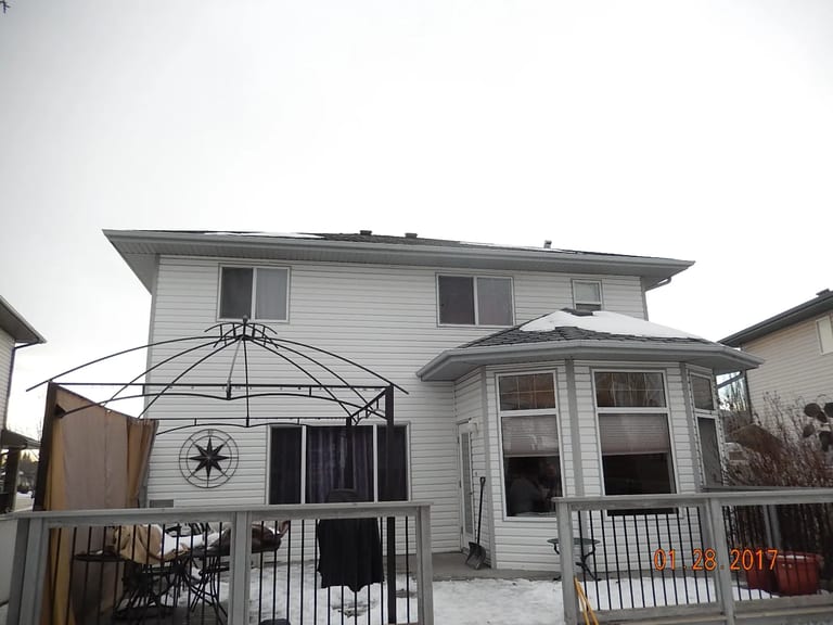 Deep Charcoal Interlock Slate aluminum roof on a white two-storey home with a metal roof in rural Alberta, Fort Saskatchewan, Alberta