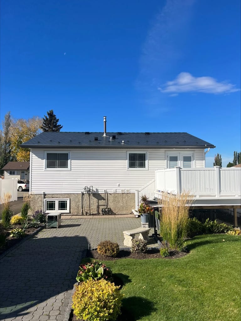 Deep Charcoal Interlock Slate aluminum roof on a white home with a metal roof in a suburban neighbourhood, Edmonton, Alberta