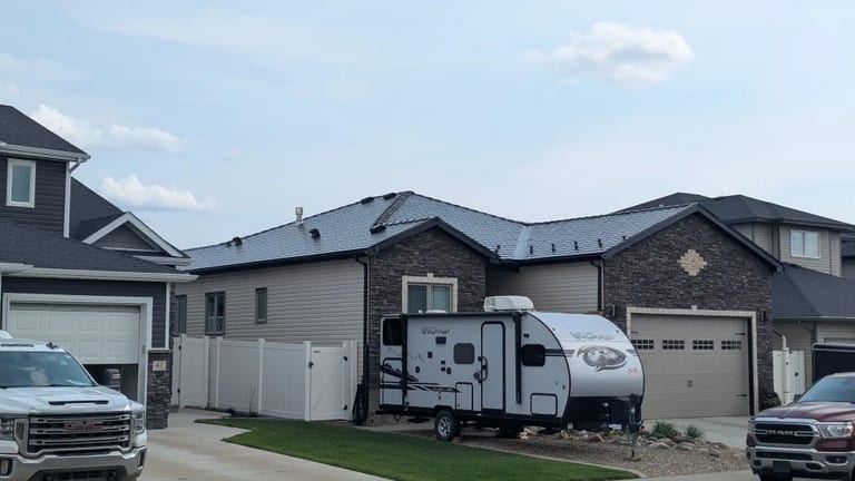 Black Interlock Slate aluminum roof on a black house with a metal roof in a rural area, Medicine Hat, Alberta