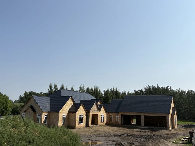 Black Interlock Slate aluminum roof on a brown home with a black metal roof among tall trees, Grande Prairie, Alberta