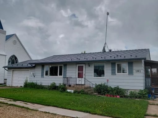 Deep Charcoal Interlock Slate aluminum roof on a Deep Charcoal metal roof on a white ranch style home in a, Edberg, Alberta