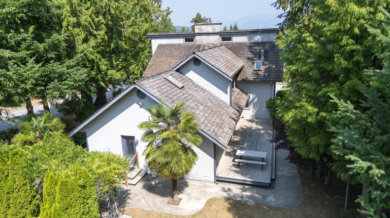 Before: Before: a mossy wood shake roof on the home, Sechelt, British Columbia, ahead of a Deep Charcoal Interlock Slate aluminum roof