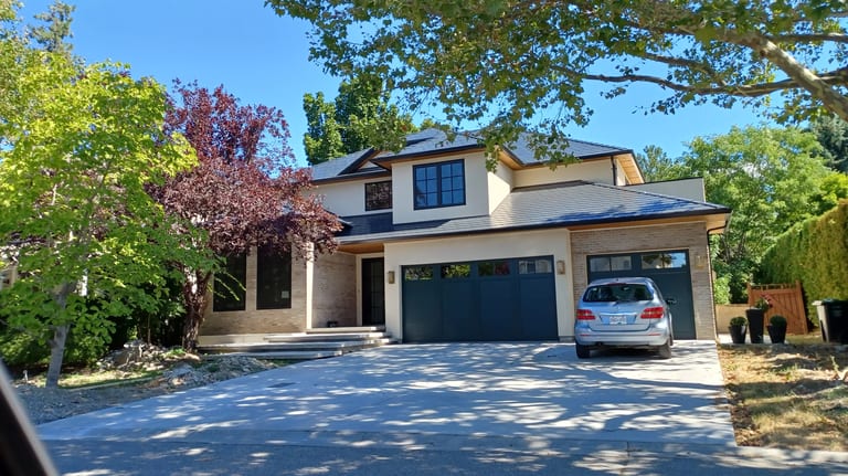 Black Interlock Slate aluminum roof on a modern home with a metal roof in a forested rural setting, Kelowna, British Columbia