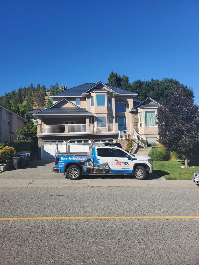 Deep Charcoal Interlock Slate aluminum roof on a modern single-family home with a metal roof in a forested, Kelowna, British Columbia