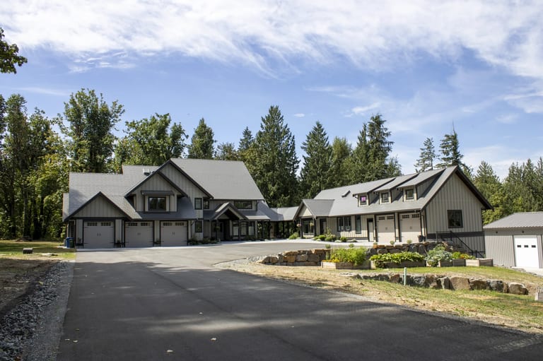 Musket Grey Interlock Slate aluminum roof on a grey modern home with dormers in a forested rural setting, Abbotsford, British Columbia