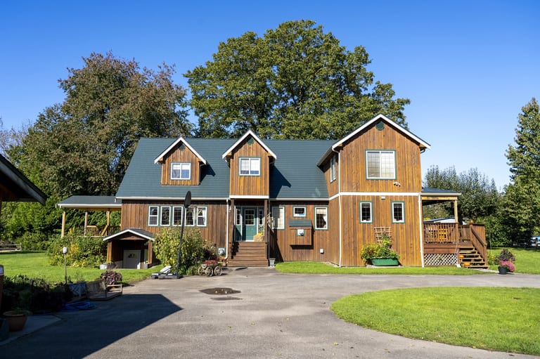 Hunter Green Interlock Slate aluminum roof on a two-storey home with a green roof in a forested area, Langley, British Columbia