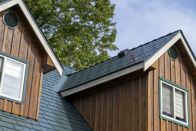 Hunter Green Interlock Slate aluminum roof on a brown house with a green roof among tall trees, Langley, British Columbia