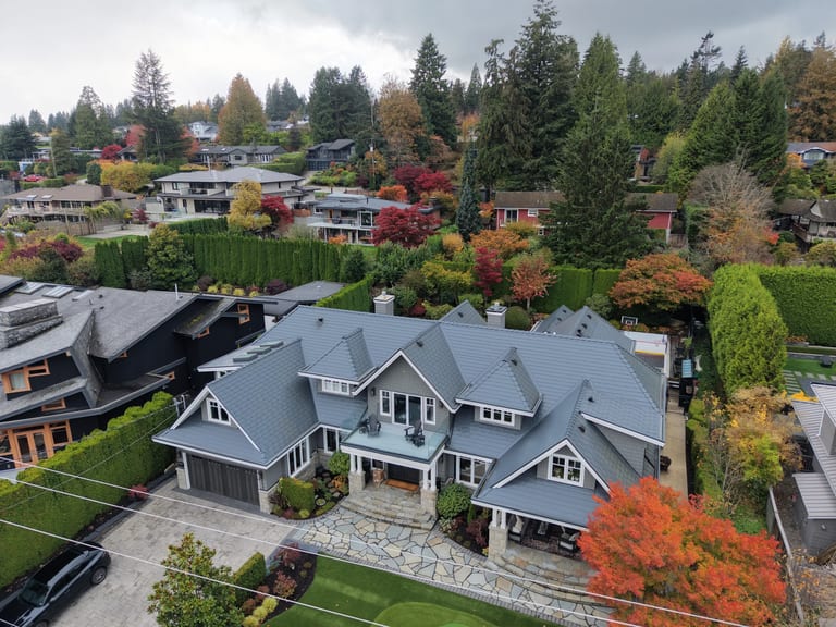 Deep Charcoal Interlock Slate aluminum roof on a Deep Charcoal metal roof on a two-storey home among tall, North Vancouver, British Columbia