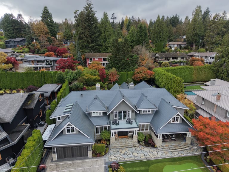 Deep Charcoal Interlock Slate aluminum roof on a grey two-storey home with dormers and a stone walkway in, North Vancouver, British Columbia