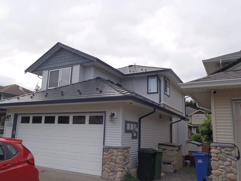 Black Interlock Slate aluminum roof on a two-storey house with a metal roof in a rural coastal, Sooke, British Columbia