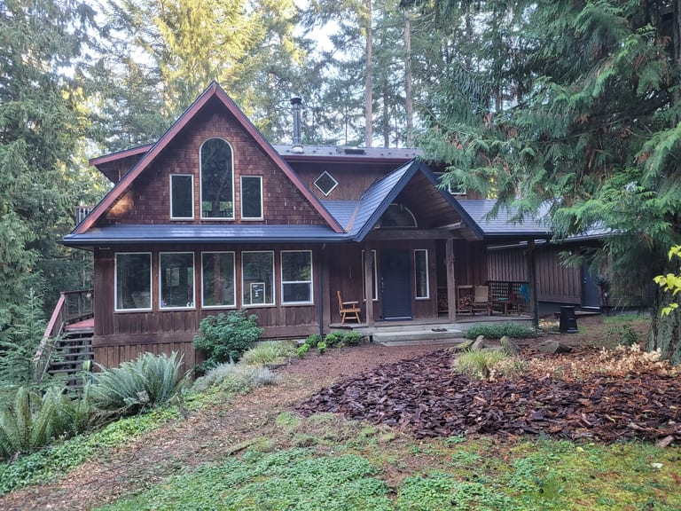 Deep Charcoal Interlock Slate aluminum roof on a brown A-Frame home with a metal roof in the forest, Gabriola Island, British Columbia