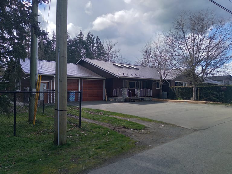 Tudor Brown Interlock Slate aluminum roof on a brown home with a metal roof in a rural setting, Duncan, British Columbia