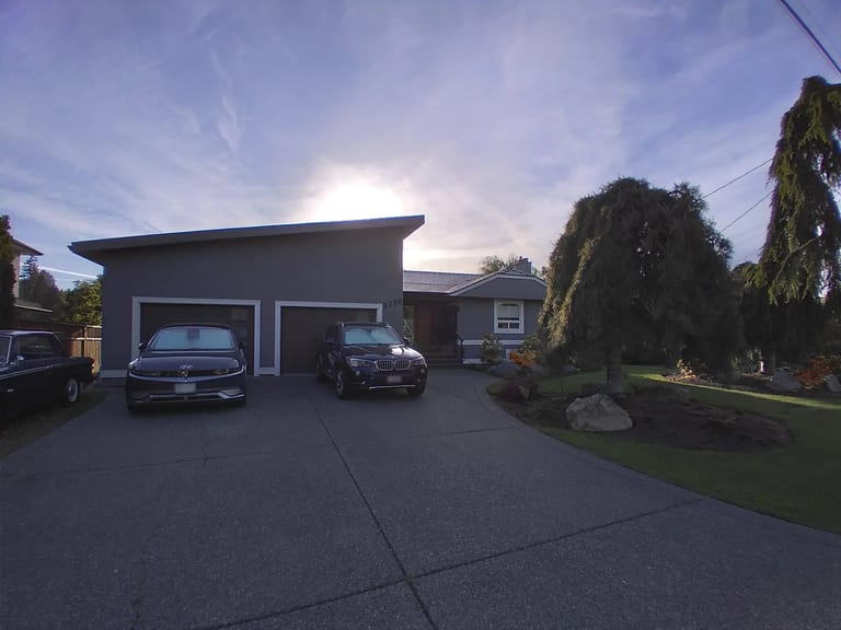 Deep Charcoal Interlock Slate aluminum roof on a grey house with a metal roof and a tree in the front yard, Victoria, British Columbia